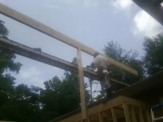 Carpenter setting a ridge beam over a new addition frame — Ice Dam Removal by Roofing Brothers in Mormon Lake